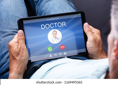 Close-up Of A Man's Hand Holding Digital Tablet With Doctor's Incoming Call On Display