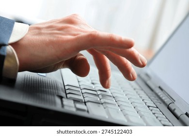 Close-up of man's hand inputing data on the laptop. Hand is in the little motion. Nikon D300, Nikkor 24-70 mm 2.8G ED, Exposure: f or 4, 70 mm.