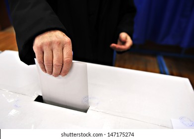 Close-up of a man's hand putting his vote in the ballot box