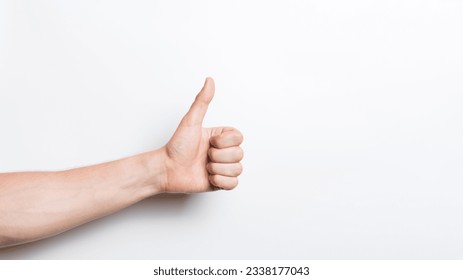 Close-up of a man's hand showing a thumbs up gesture isolated on a white studio background. - Powered by Shutterstock