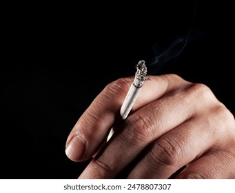 Close-up of a man's hand smoking a cigarette in the dark - Powered by Shutterstock