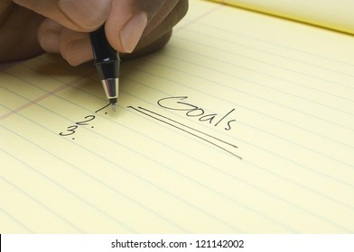 Closeup Of Man's Hand Writing Goals On Notepad