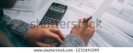 Close-up of a man's hands with a calculator and a lot of utility bills on the table. The man considers the costs of gas, electricity, heating. The concept of increasing tariffs for services [[stock_photo]] © 