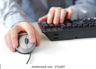 Closeup of man's hands with computer mouse and keyboard