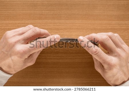 Closeup mans hands counting dollar bills on wooden table, smallbusiness owner reconciling cash receipts, warm lighting, sharp focus on fingers and bill texture, practical budgeting