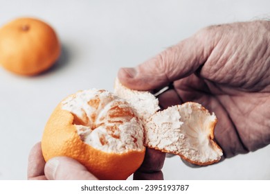 Close-up of a man's hands peeling an orange. Man peeling fruit. - Powered by Shutterstock