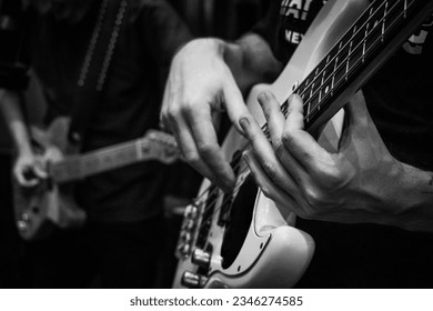 Close-up of man's hands playing bass guitar. Person playing bass guitar. Guitar strings. Person playing rock. Musical instrument - Powered by Shutterstock