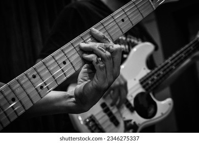 Close-up of man's hands playing bass guitar. Person playing bass guitar. Guitar strings. Person playing rock. Musical instrument - Powered by Shutterstock