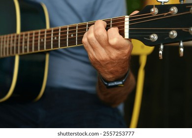 Close-up of a man's hands playing an E chord on acoustic guitar at home chord on acoustic guitar at home - Powered by Shutterstock - Get 15% off with code: PIKWIZARD15