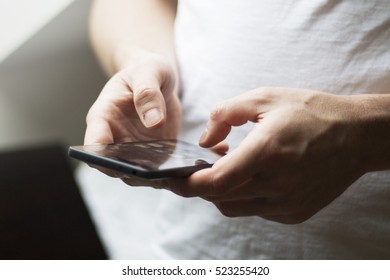 Closeup of man's hands texting on a phone