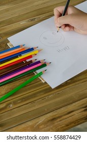 Closeup to man's hands using a Crayon on a paper sheet