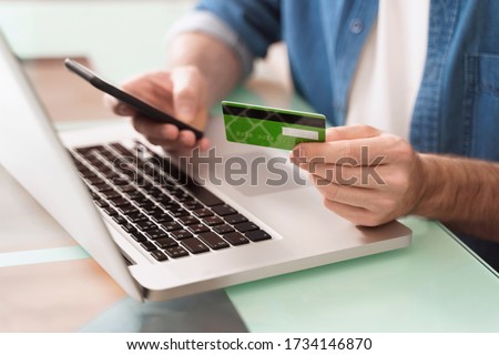 Closeup of man's hands using smartphone, laptop and credit card for e-commerce. Online shopping. E-banking concept. Digital Payment gateway