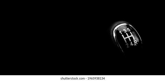 Close-up of a manual gearbox lever shift isolated on black background. Empty place for text, wide banner - Shutterstock ID 1965938134