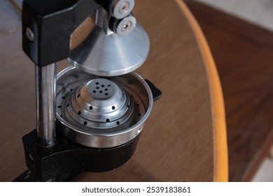 Close-up of a manual metal citrus juicer in a kitchen. Perfect for fresh juice preparation and healthy living concepts. - Powered by Shutterstock