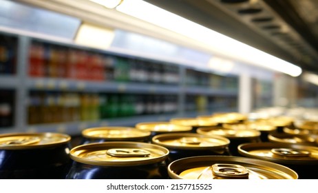 Close-up Of Many Golden Black Cans Of Beer Or Energy Drink On A Store Fridge Shelf