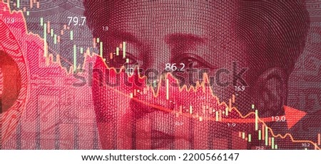 Closeup Mao Tse Tung face on Yuan banknote with stock market chart graph for currency exchange  global trade forex and China business economic recession concept.