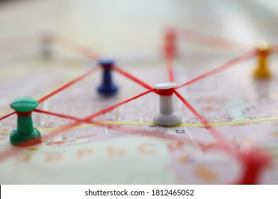 Close-up Of Map Marked With Red Thread Paths Of Movement. Plan Of Street With Buttons Forming Route. Pedestrian Building Route Around City. Navigation Concept