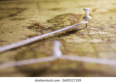 Close-Up of Map with Pin and Connected String Indicating Travel Planning