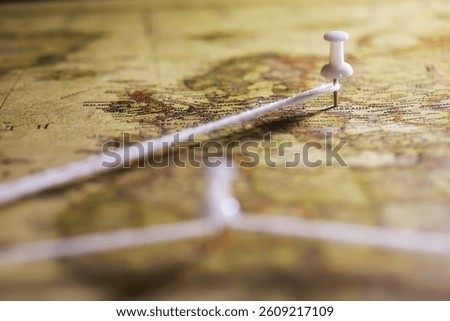Close-Up of Map with Pin and Connected String Indicating Travel Planning