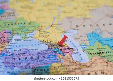 A close-up map with a red pushpin marking the region of Georgia, Armenia, and Azerbaijan near the Caspian Sea. Concept image for travel destinations, geography, and international borders.
