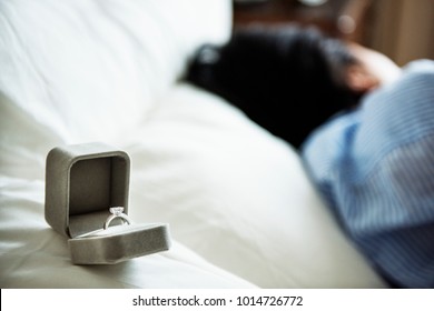 Closeup Of Marriage Proposal Ring On Bed