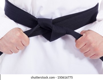 Closeup of a martial arts man tying his black belt - Powered by Shutterstock