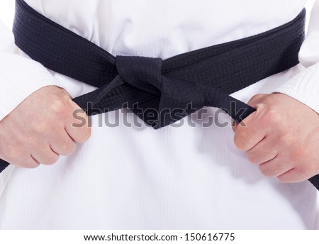 Closeup of a martial arts man tying his black belt
