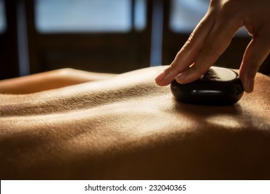 Closeup of massage with hot stones. Spa treatment.