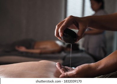 Closeup of masseur hands pouring aroma oil on woman back. Masseuse prepare to do oriental spa procedure for relaxing treatment. Therapist doing aromatherapy oil massage on woman body. - Shutterstock ID 1832039170