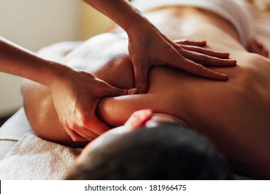 Close-up of masseur's hands massaging a client's back