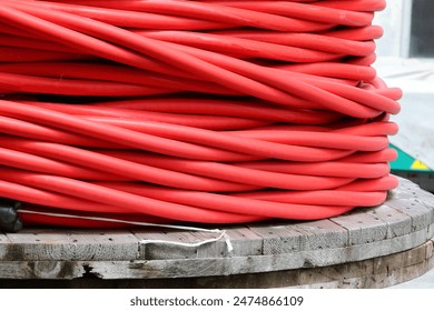 Close-up of a massive red electrical cable spool for distributing high-voltage electricity