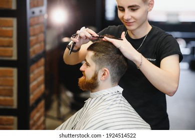 Close-up, master hairdresser does hairstyle and style with scissors and comb. Concept Barbershop.