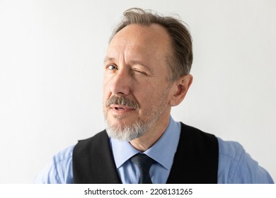Close-up of mature businessman winking at camera. Senior Caucasian manager wearing formalwear looking at camera and hinting against white background. Flirt or hint concept - Shutterstock ID 2208131265