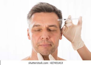 Close-up Of Mature Man Get Injection On His Face