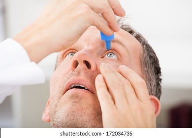 Close-up Of A Mature Man Putting Eye Drops In Eyes