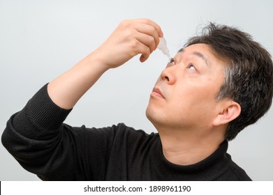 Close-up Of A Mature Man Putting Eye Drops In Eyes