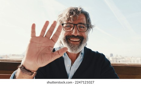 Close-up of mature man taking selfie while standing on balcony, looks at camera - Powered by Shutterstock