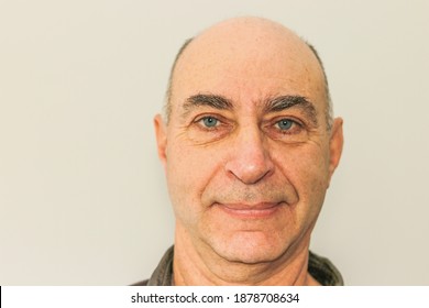 Close-up of a mature man's face. Bald with blue eyes and a slight smile on his lips. Look straight into the camera. - Powered by Shutterstock