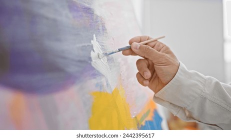 Close-up of a mature man's hand painting on canvas in a well-lit studio, showcasing his artistic skills. - Powered by Shutterstock