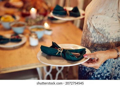 Close-up Of Mature Woman Decorates Dinning Table For Christmas Dinner.