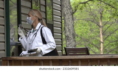 Closeup of mature woman doctor or nurse wearing face mask and gloves making a house call home visit in a rural area. - Powered by Shutterstock