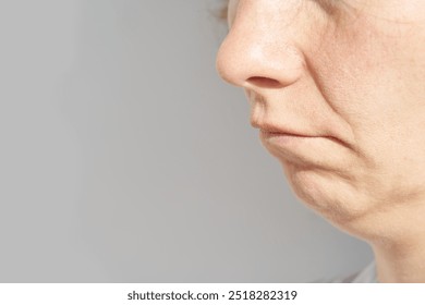 Close-up of mature woman's lower face showing natural skin texture and signs of aging - Powered by Shutterstock