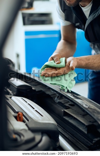Close-up of mechanic cleaning his hands after\
repairing car engine in a\
workshop.