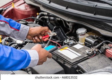 Close-up Of Mechanic Hands Using Multimeter For Checking Battery In Car