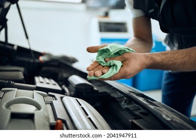 Close-up Of Mechanic Wiping His Dirty Hands After Working On Car Engine At Auto Repair Shop. 