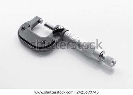 Close-up of a mechanical micrometer on a light background. Vintage measuring tool.