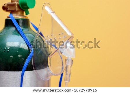 Close-up of Medical Oxygen Tank with Mask Hanging from Side