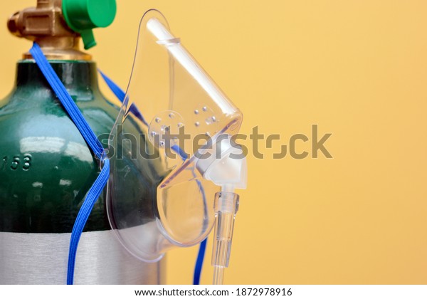Close-up of Medical Oxygen Tank with Mask Hanging\
from Side