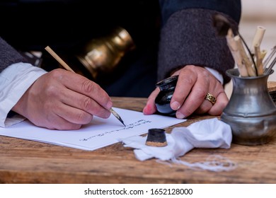 Close-up Of A Medieval Scribe, With A Pen, Paper And An Inkwell