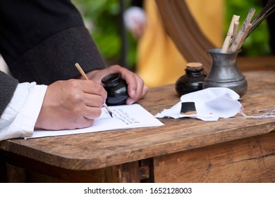 Close-up Of A Medieval Scribe, With A Pen, Paper And An Inkwell